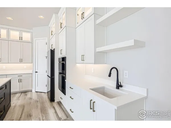 a kitchen with a sink a chandelier and living room view