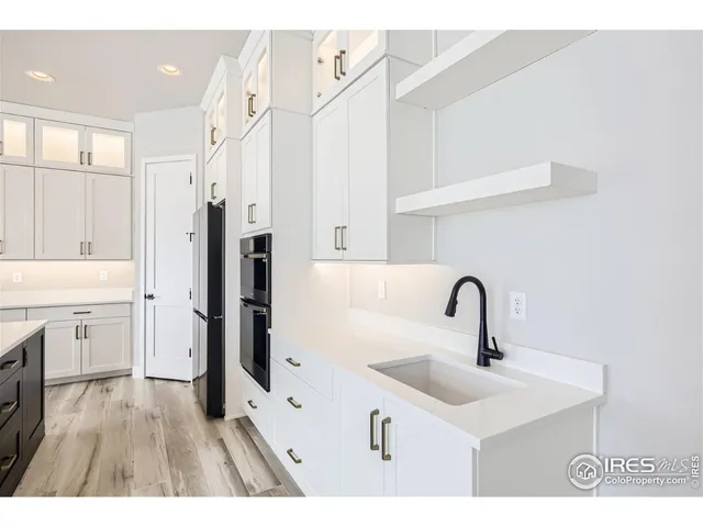 a kitchen with a sink a chandelier and living room view