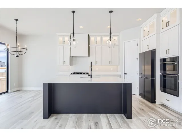 a view of empty room with wooden floor and ceiling fan
