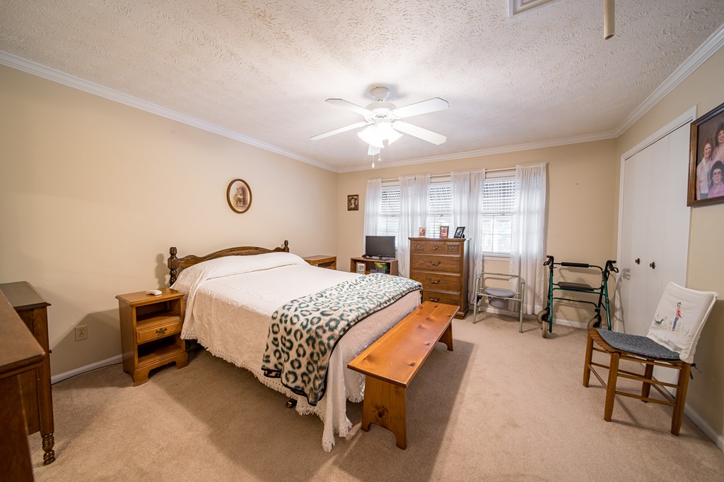 6101 River Road, Unit 42 Columbus, GA 31904 - Photo 16 of 28 a bedroom with a bed a chair and a chandelier