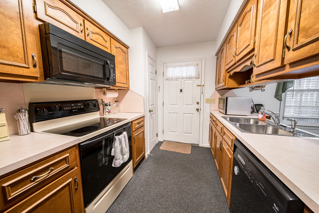 6101 River Road, Unit 42 Columbus, GA 31904 - Photo 10 of 28 a kitchen with stainless steel appliances a stove a sink and a microwave