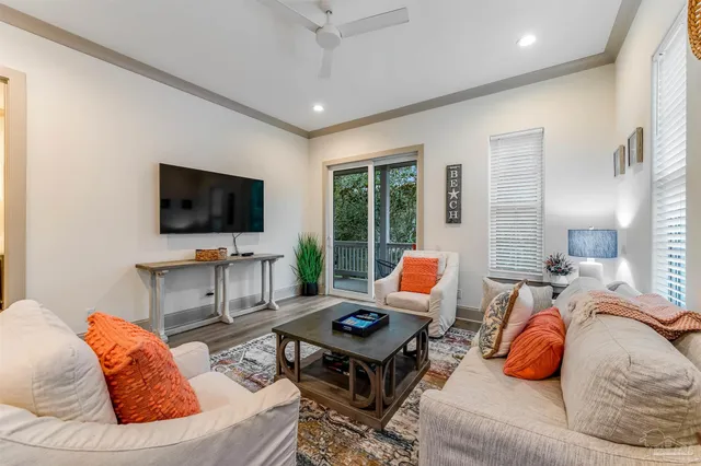 a living room with furniture kitchen view and a flat screen tv