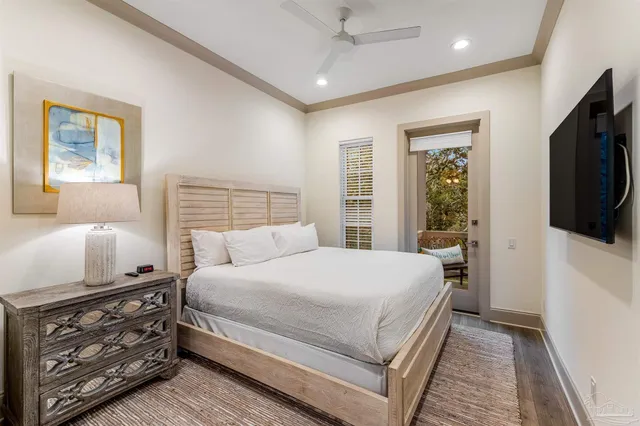 a bedroom with a large bed a flat tv screen and a dresser