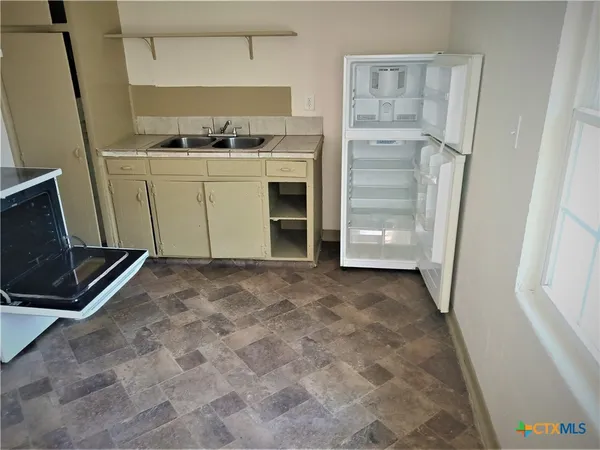 a view of a kitchen with refrigerator and cabinet