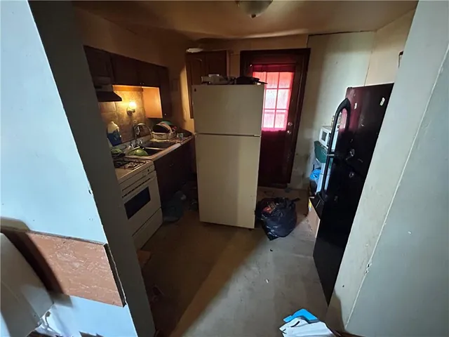 a view of a refrigerator in kitchen and a window