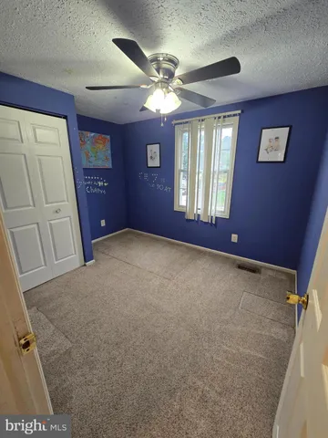 a furnished livingroom with windows and ceiling fan