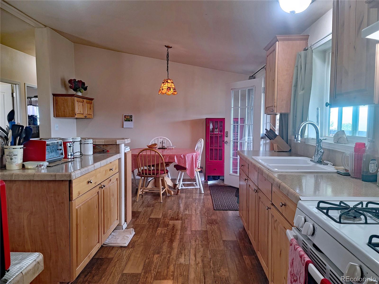 2252 White Tail Road, Unit 2 San Luis, CO 81152 - Photo 11 of 44 a kitchen that has a lot of cabinets a sink and wooden floor