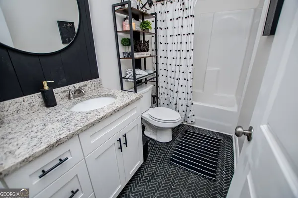 a bathroom with a granite countertop sink mirror vanity and toilet