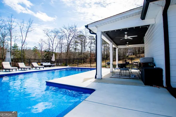 a view of swimming pool with outdoor seating and a patio
