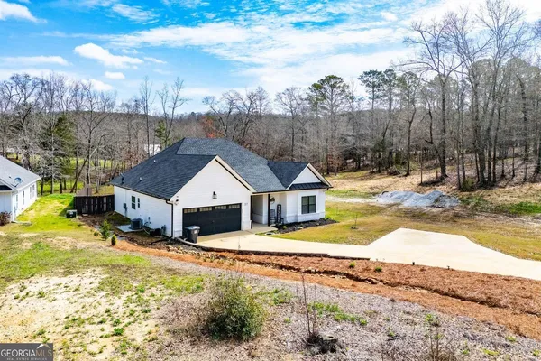 a view of a white house with a yard covered with snow