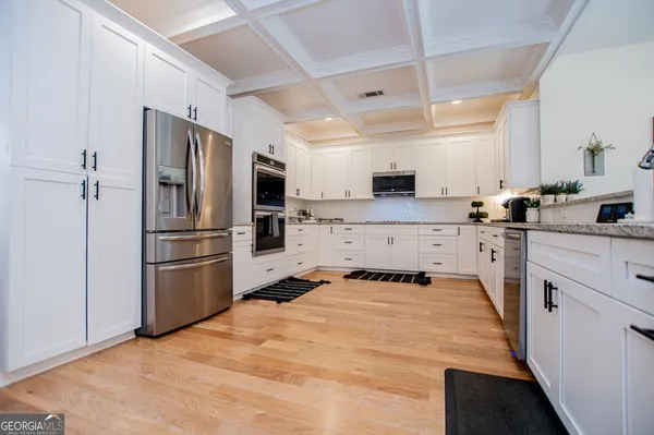 a kitchen with a refrigerator a sink and cabinets