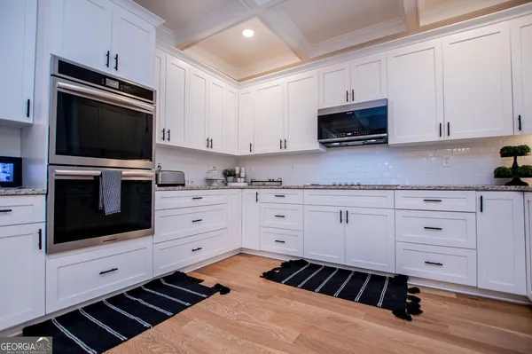 a kitchen with white cabinets and appliances