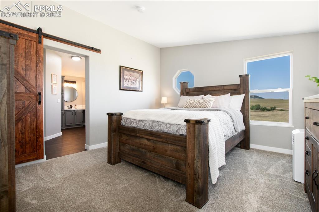 11100 Haskel Creek Road Larkspur, CO 80118 - Photo 25 of 49 a bedroom with a bed and a table