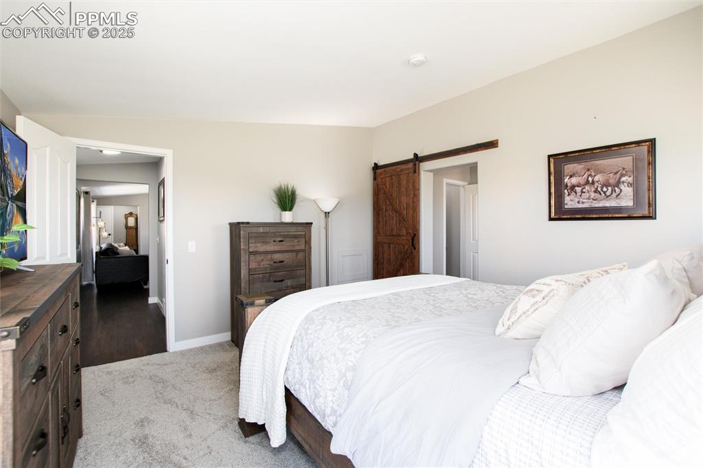 11100 Haskel Creek Road Larkspur, CO 80118 - Photo 27 of 49 a spacious bedroom with a bed and a dresser