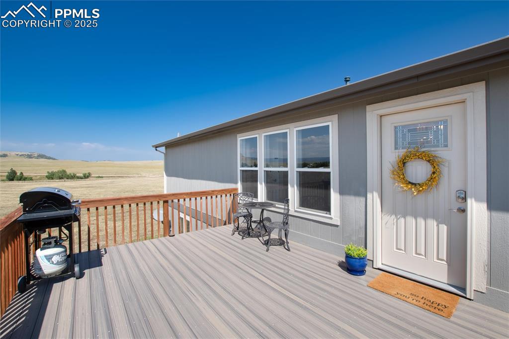 11100 Haskel Creek Road Larkspur, CO 80118 - Photo 10 of 49 a view of a balcony with wooden floor and iron fence