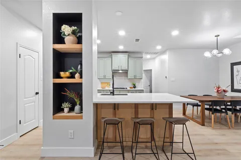 a kitchen with stainless steel appliances kitchen island hardwood floor sink and stove