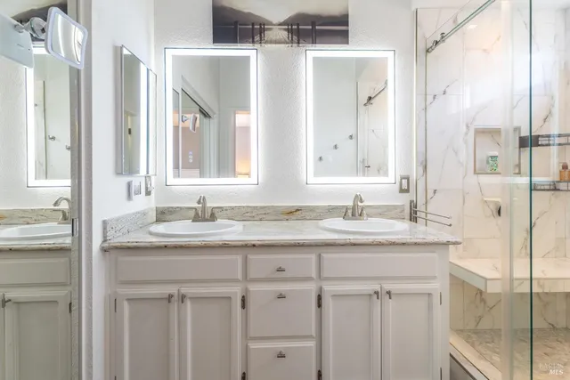 a bathroom with double sink and a mirror