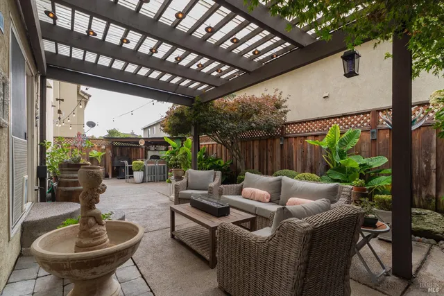 a patio with couple of chairs and a barbeque