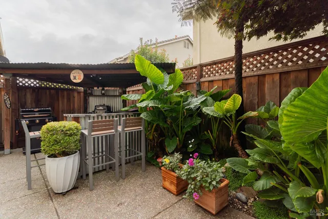 a view of a patio with chairs and a grill