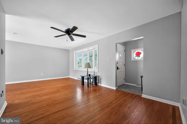 a view of a workspace with wooden floor and a ceiling fan