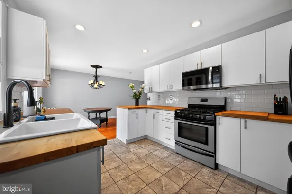 a kitchen with granite countertop a sink stainless steel appliances and cabinets