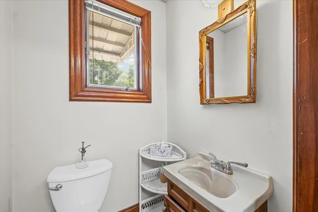 a bathroom with a toilet a sink and a mirror