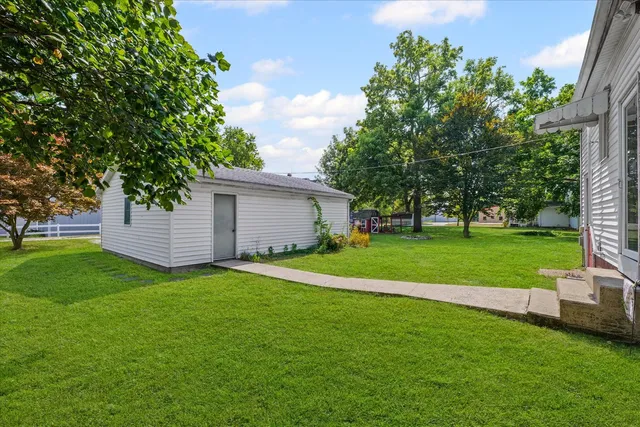 a front view of a house with a yard and trees