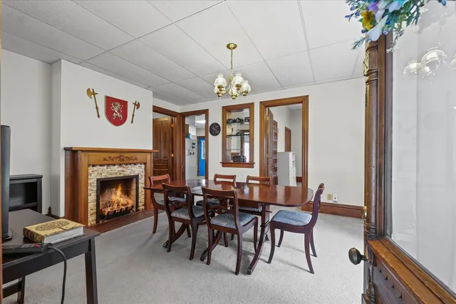 a dining room with furniture a fireplace and a chandelier