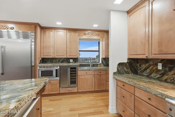 a kitchen with stainless steel appliances granite countertop a stove a sink and a refrigerator