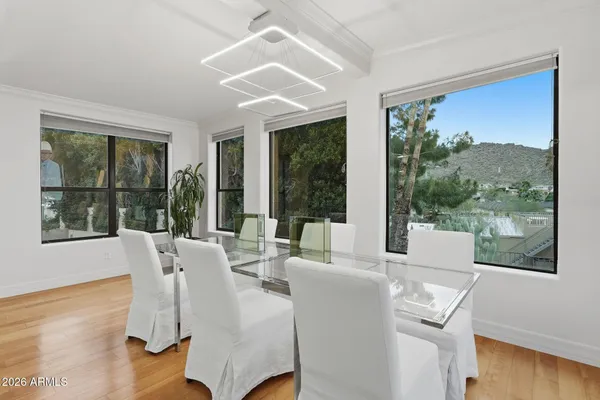 a dining room with furniture large windows and wooden floor