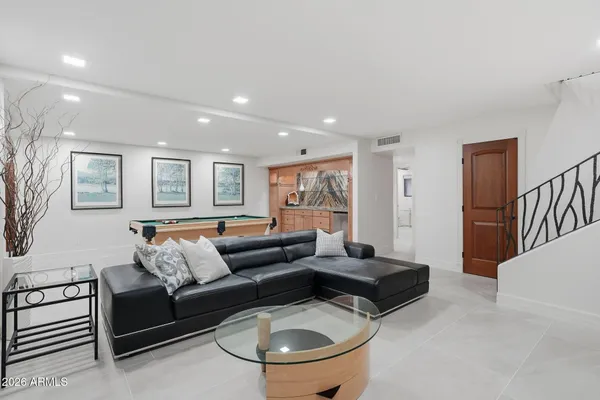 a living room with furniture and a dining table with wooden floor