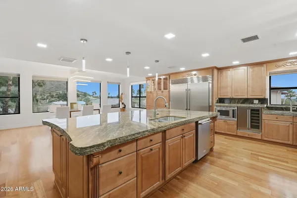 a kitchen with stainless steel appliances granite countertop a sink and a counter top space