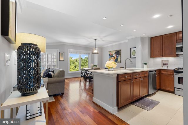 a large living room with stainless steel appliances granite countertop a couch a rug a lamp and a window