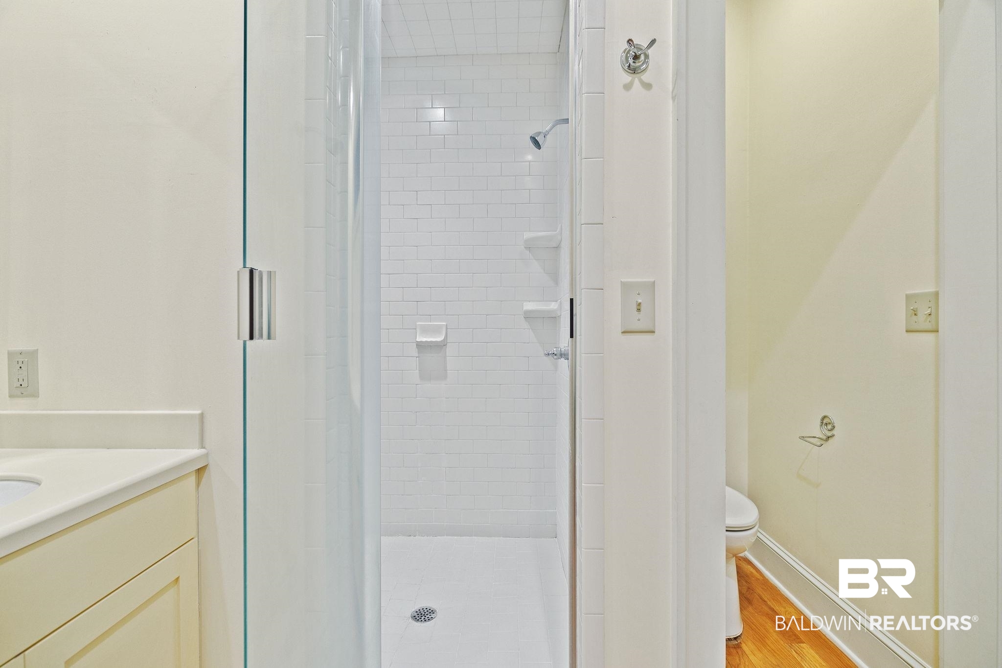 202 Beall Lane Daphne, AL 36526 - Photo 25 of 46 Bathroom featuring tiled shower, hardwood / wood-style flooring, toilet, and vanity