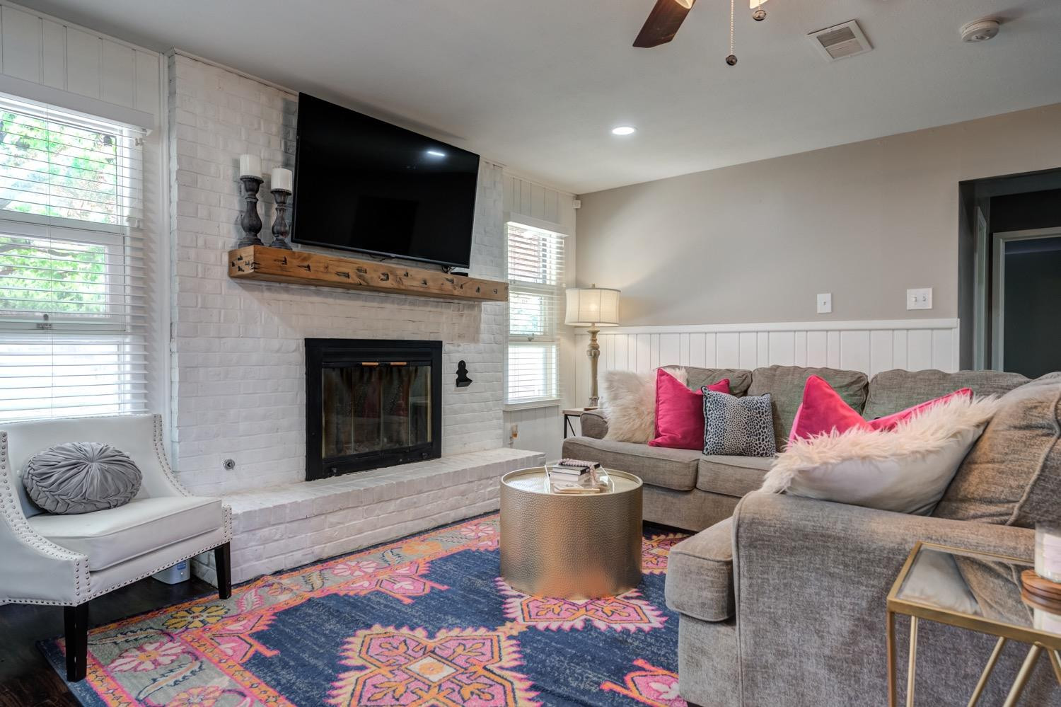2306 61st Street Lubbock, TX 79412 - Photo 12 of 35 a living room with furniture a flat screen tv and a fireplace