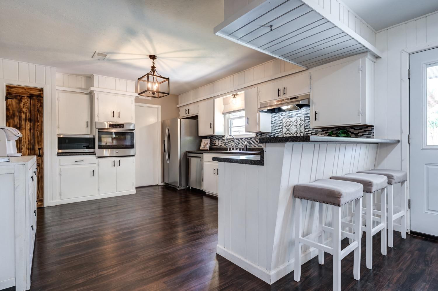 2306 61st Street Lubbock, TX 79412 - Photo 19 of 35 a kitchen with stainless steel appliances granite countertop a table chairs refrigerator and cabinets