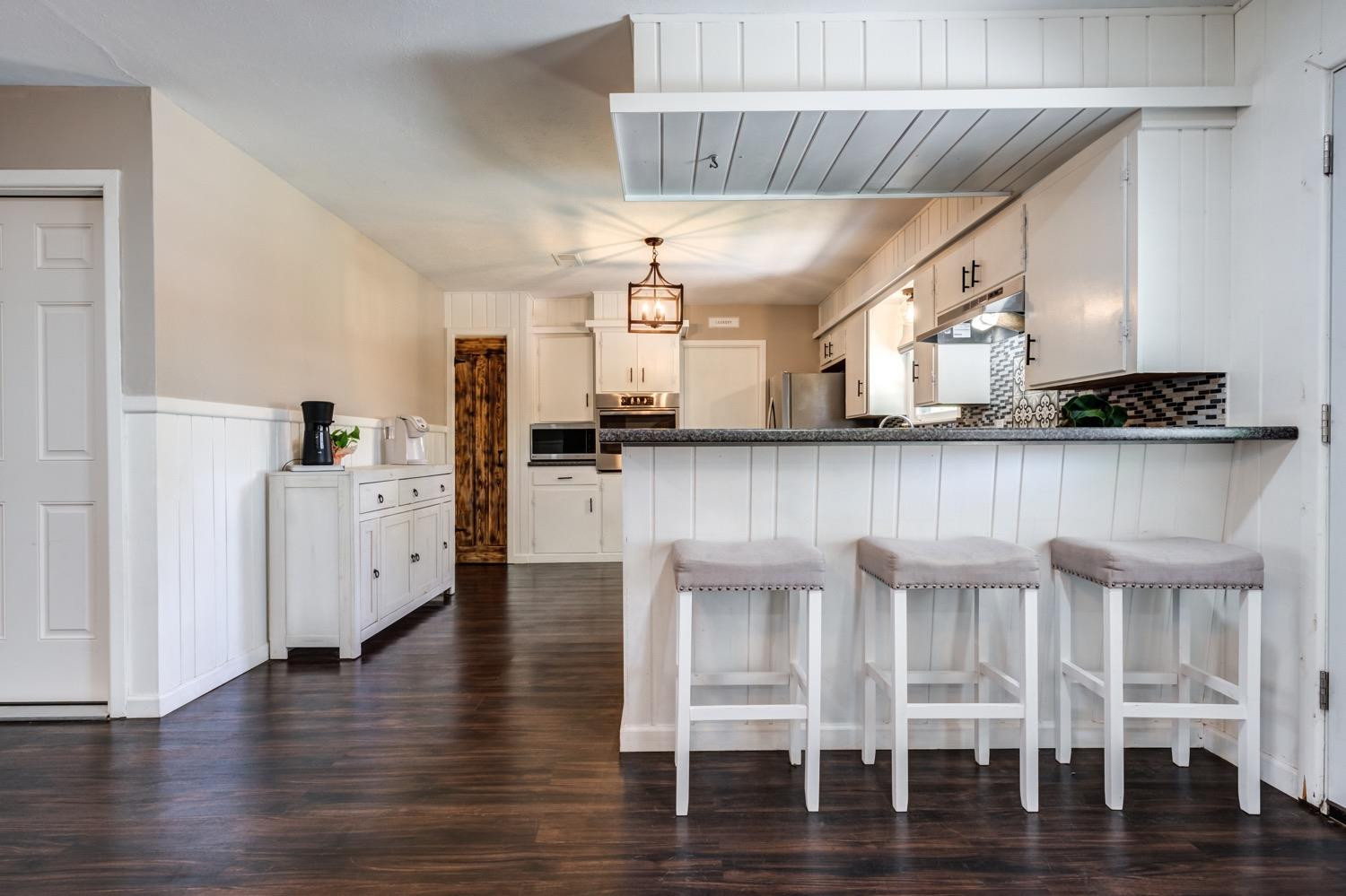 2306 61st Street Lubbock, TX 79412 - Photo 20 of 35 a kitchen with stainless steel appliances granite countertop a table chairs refrigerator and sink