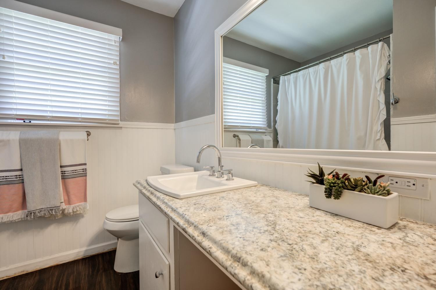 2306 61st Street Lubbock, TX 79412 - Photo 27 of 35 a bathroom with a granite countertop sink and a toilet