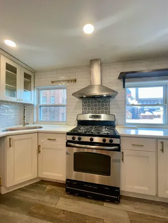 a kitchen with a stove and white cabinets