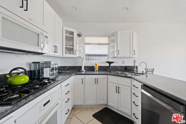 a kitchen with stainless steel appliances granite countertop a sink a stove and cabinets