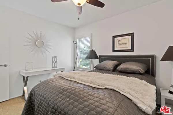 a bedroom with a large bed and a chandelier