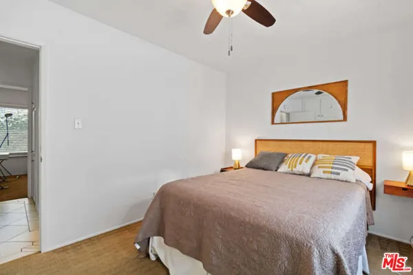 a bedroom with a bed and a painting on the wall