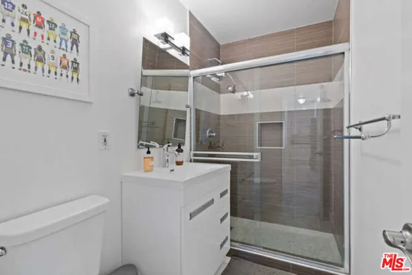 a bathroom with a sink a toilet and shower