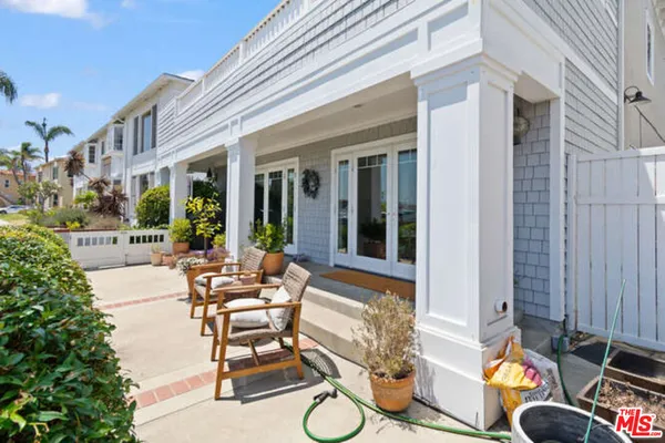 a view of a patio with couches table and chairs and potted plants
