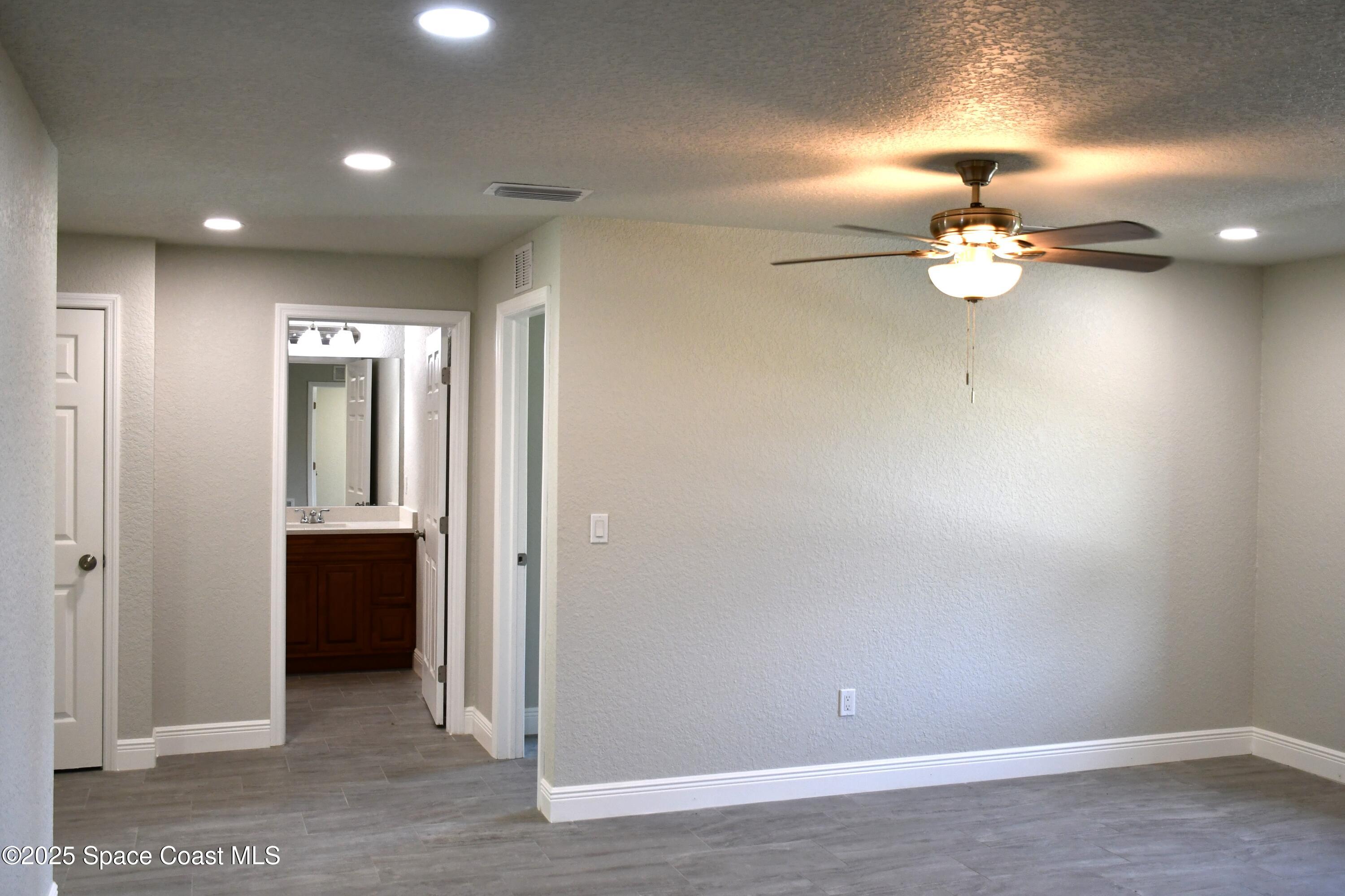 1515 Furnari Street Cocoa, FL 32922 - Photo 10 of 14 a view of a chandelier fan and a wooden floor