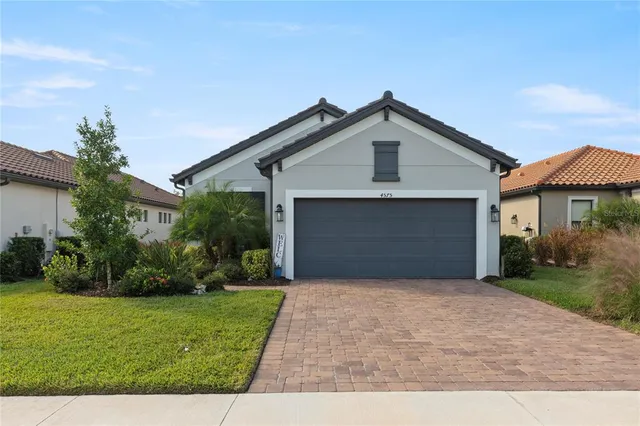 a front view of a house with a yard and garage