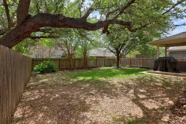 a view of a house with backyard and a tree