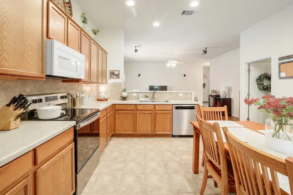 a kitchen with a sink a counter top space stainless steel appliances and cabinets