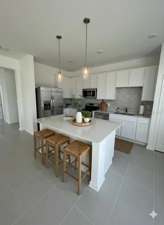 a large kitchen with kitchen island a sink a counter space and stainless steel appliances
