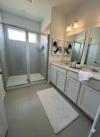 a bathroom with a sink a mirror and shower